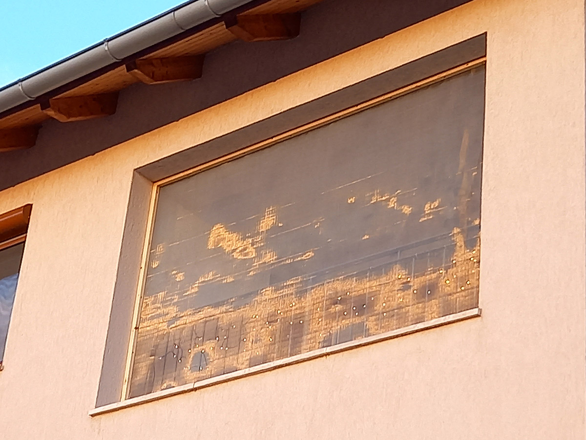 Erkély "ablak" fém szúnyoghálózás után kívülről a naplementében.